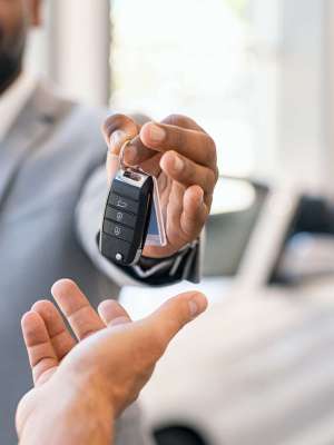 Closeup,Hand,Of,Cardealer,Giving,New,Car,Key,To,Customer.