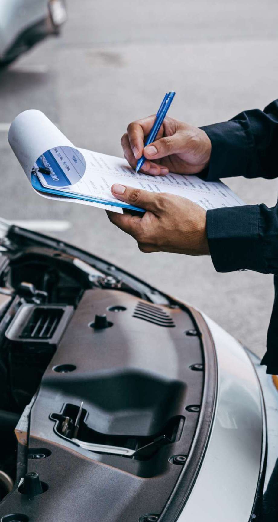 Mechanic check list to the clipboard insurance with inspecting car at garage workshop, Car auto services and maintenance check concept.